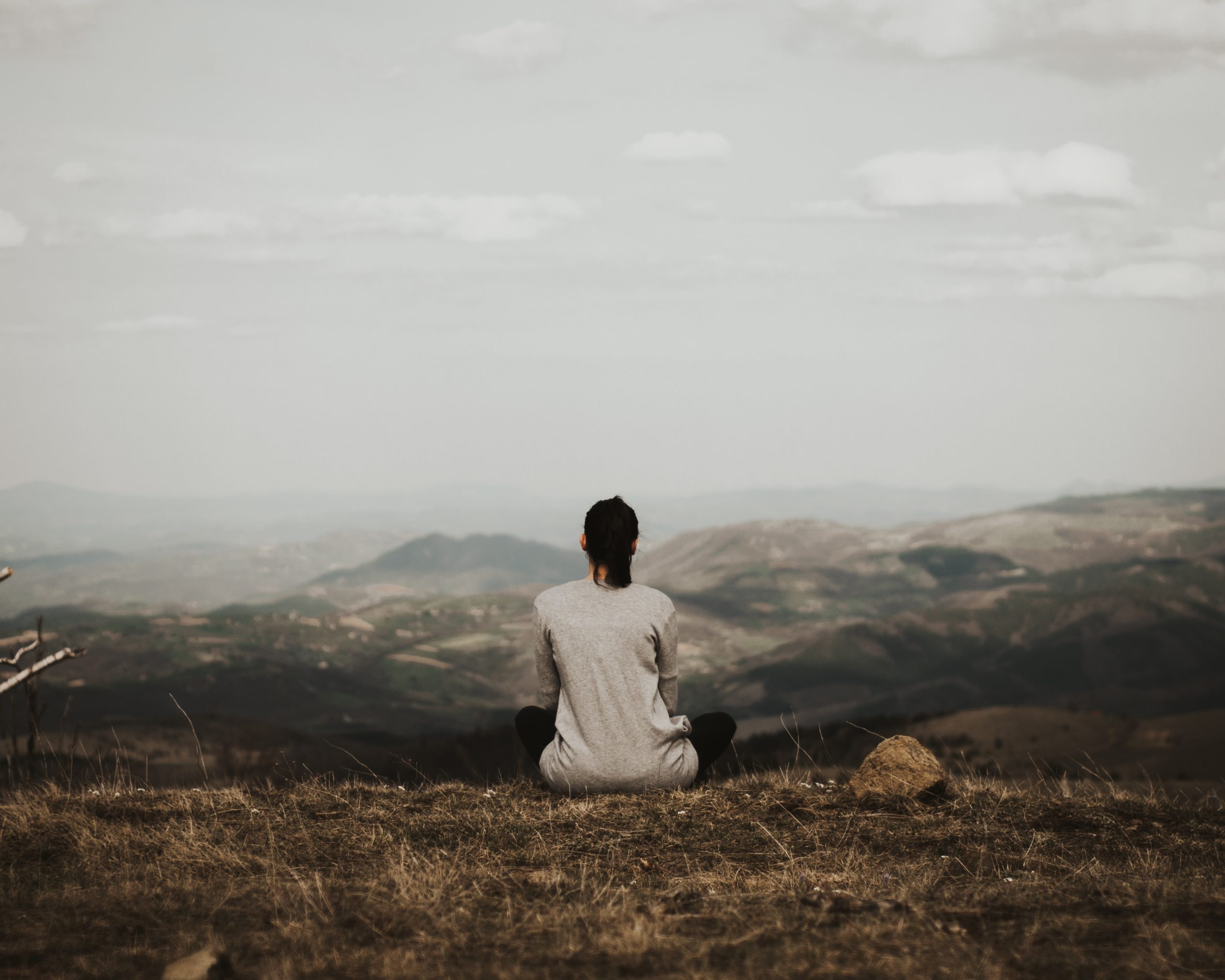 A Women is Meditating on the top of the Mountain